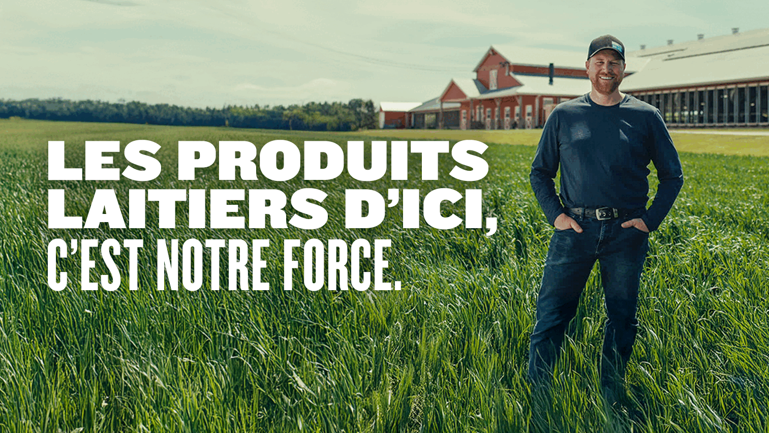 Un producteur laitier canadien souriant se tient dans un champ vert, avec une ferme rouge en arrière-plan. Un grand texte blanc superposé à l’image indique : « Choisir canadien, choisir plus fort ».