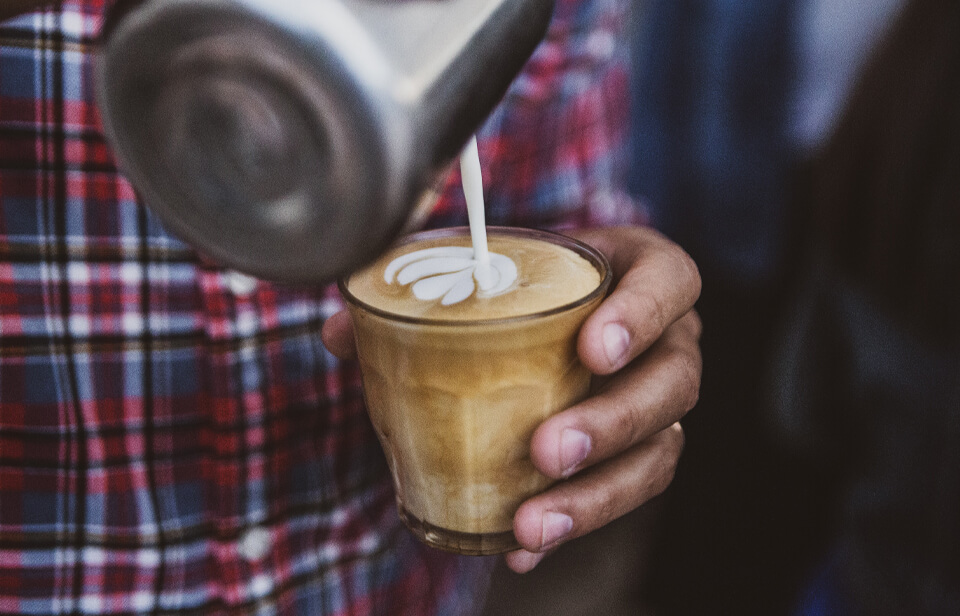 Un barista prépare un café au lait