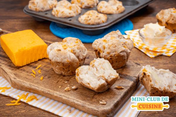 Petits pains au fromage avec du beurre sur une planche à découper