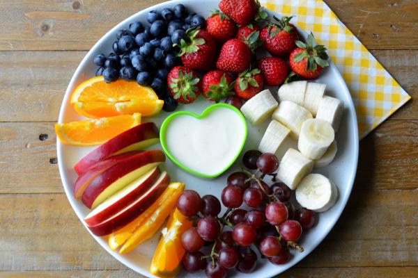 Trempette à l’orange servi dans un bol en forme de cœur avec des fruits
