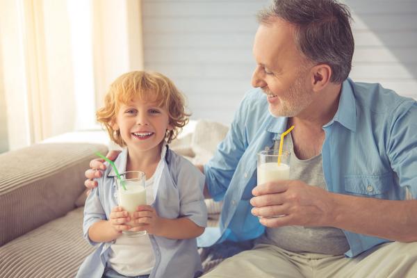 Un jeune garçon et son grand-père ont chacun leur verre de lait