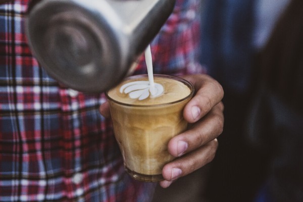 Un barista prépare un café au lait