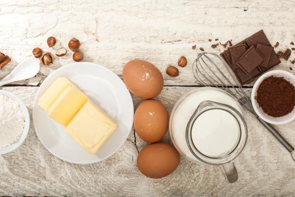 Du beurre ramolli et d’autres ingrédients sur un comptoir de bois
