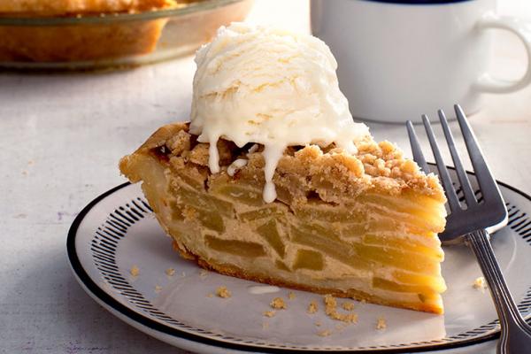 Tranche de tarte aux pommes à la crème sure avec de la crème glacée fondante sur le dessus, un dessert classique avec une touche