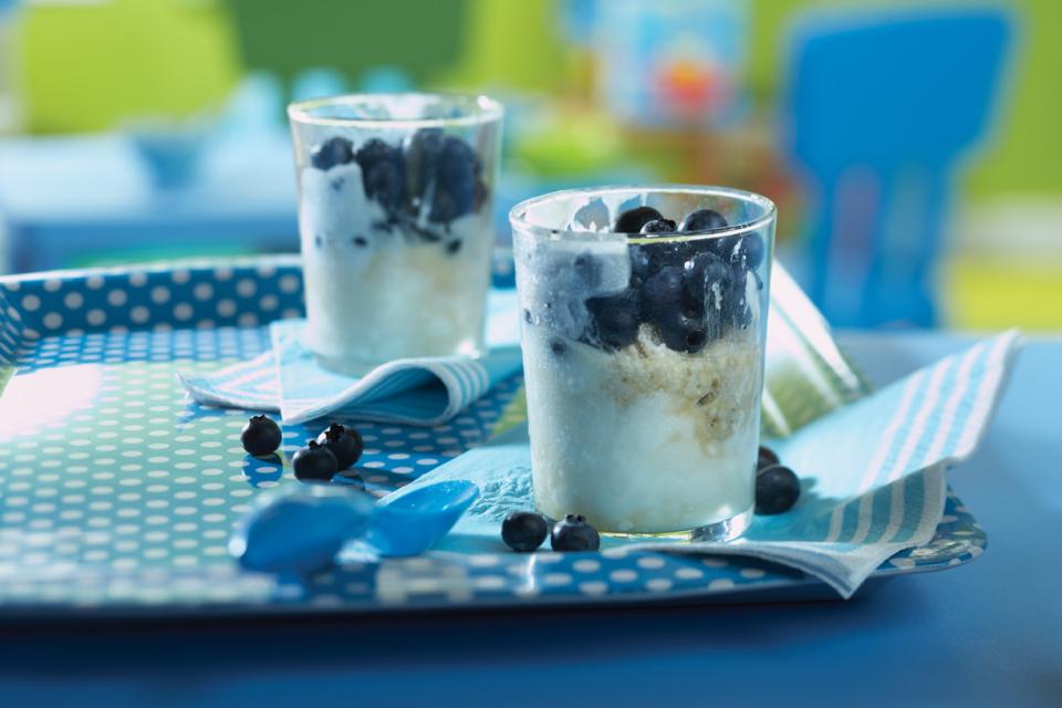 Parfait aux bleuets fait avec de l'avoine, du yogourt et des bleuets dans de petits verres sur un plateau