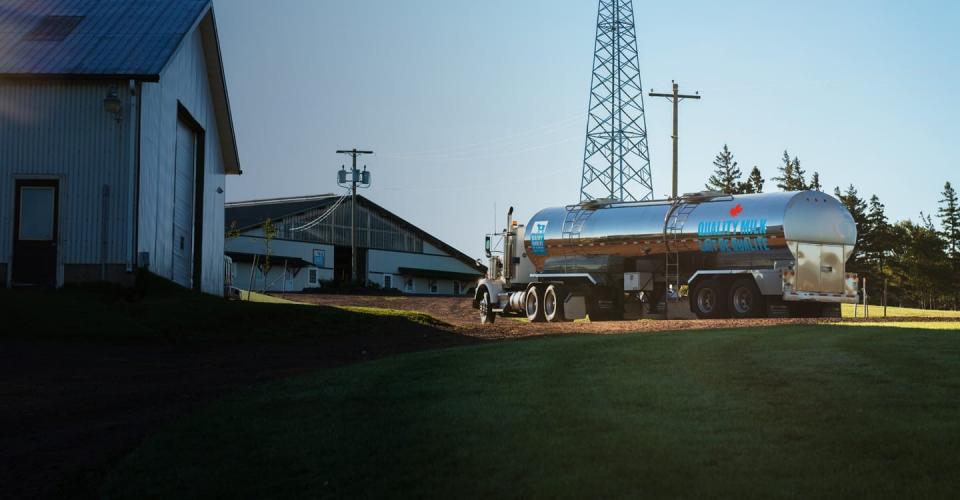 Un camion de lait arrive sur une ferme canadienne.