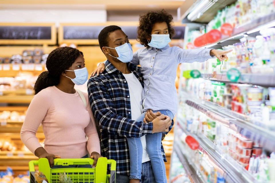 Un homme et une femme achètent des produits laitiers avec leur jeune enfant