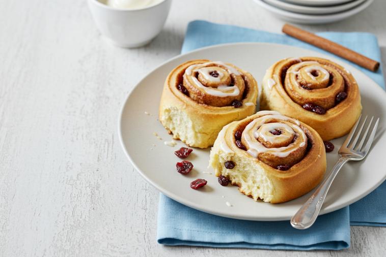 Trois brioches à la cannelle avec des canneberges séchées sur une assiette
