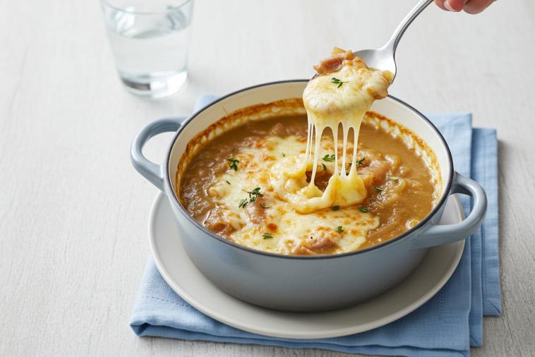 Soupe à l'oignon crémeuse garnie de fromage fondu grillé dans un bol