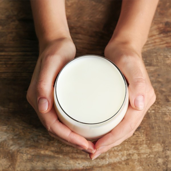 Deux mains tenant un verre de lait, vu d'en haut