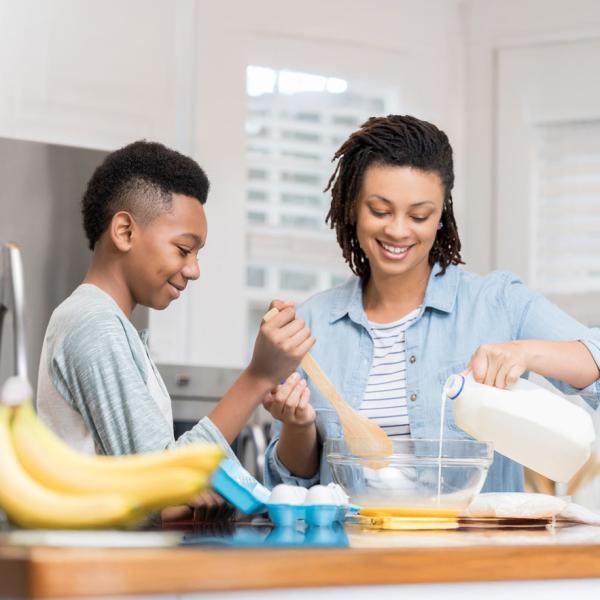 Mother and son preparing a meal with milk